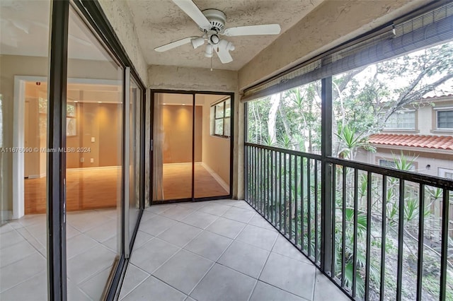 unfurnished sunroom with ceiling fan