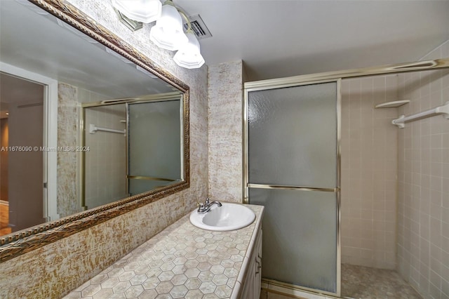 bathroom with vanity, a shower with shower door, and tile patterned floors