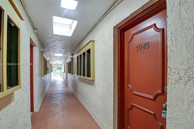 hallway with a skylight and concrete flooring