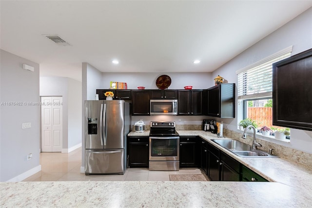 kitchen with light tile patterned flooring, stainless steel appliances, and sink