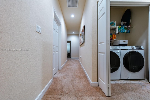 laundry room with washer and dryer and light carpet