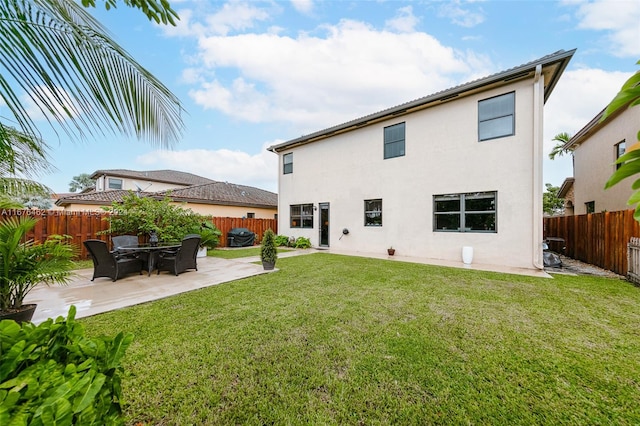 rear view of house featuring a patio and a yard