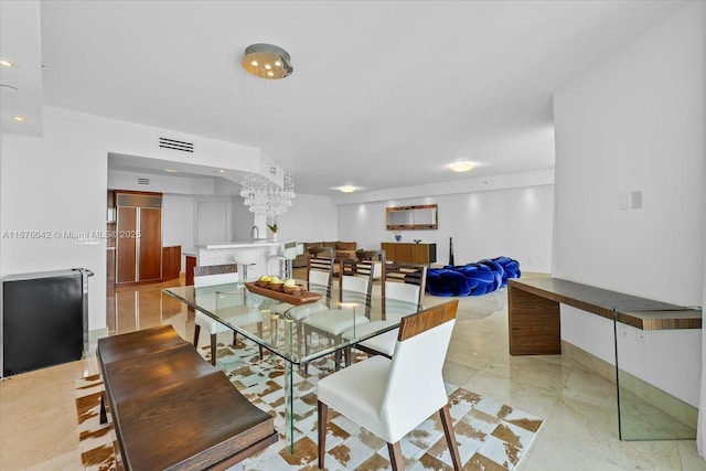 dining space with light tile patterned floors and an inviting chandelier