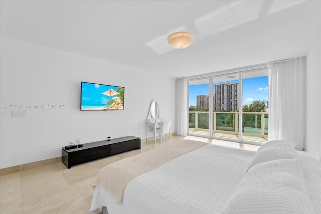 bedroom with access to outside and a wall of windows