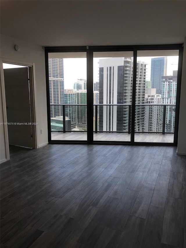 801 S Miami Ave Unit 3903, Miami, FL 33130 - unfurnished room featuring a wall of windows, dark wood-type flooring, baseboards, and a smoke detector