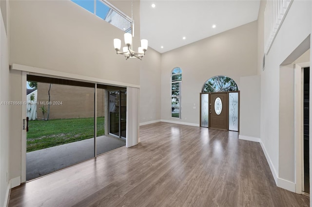 foyer featuring a high ceiling, wood-type flooring, and an inviting chandelier