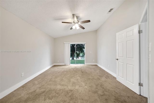 carpeted empty room with a textured ceiling, ceiling fan, and vaulted ceiling