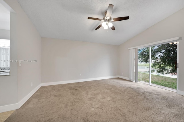 carpeted spare room with lofted ceiling, a textured ceiling, and ceiling fan