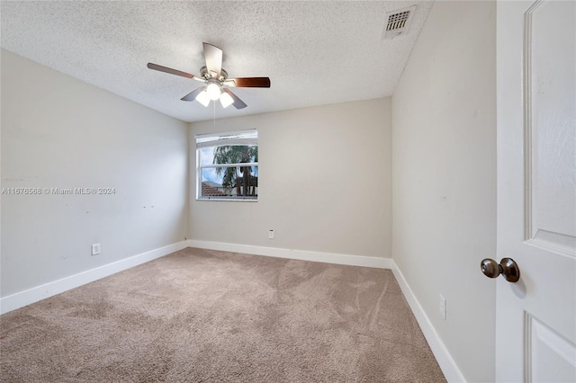 carpeted empty room featuring a textured ceiling and ceiling fan