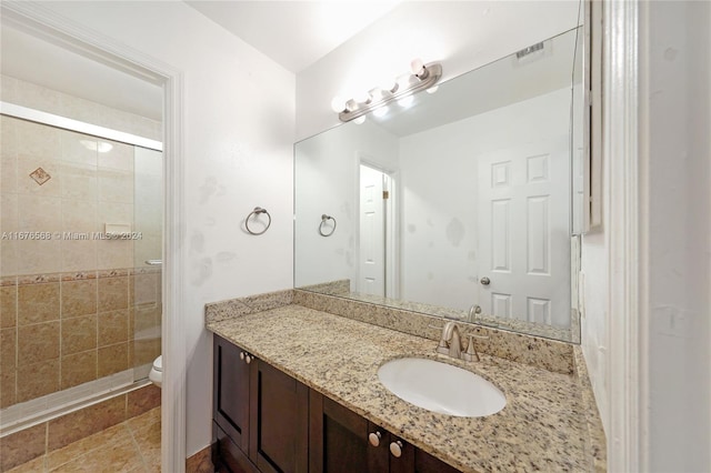 bathroom with vanity, toilet, and a shower with shower door