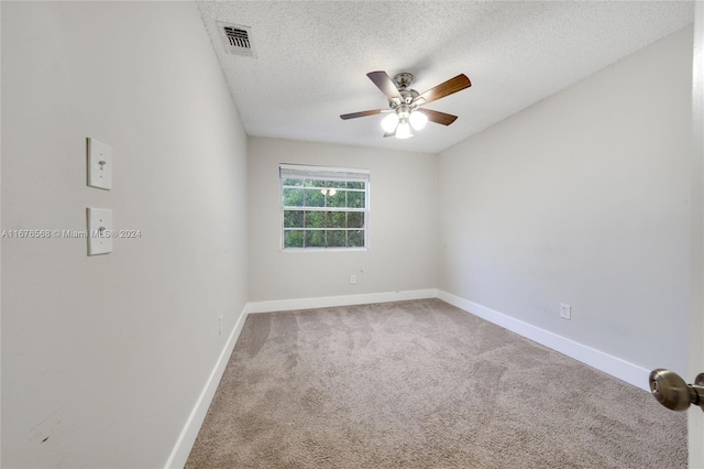 carpeted empty room with ceiling fan and a textured ceiling