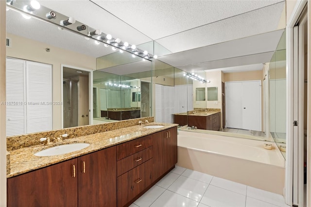 bathroom with tile patterned flooring, a textured ceiling, vanity, and independent shower and bath