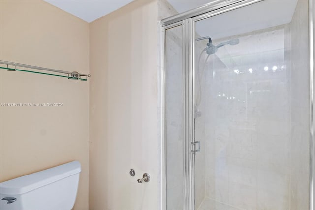 bathroom featuring walk in shower and toilet