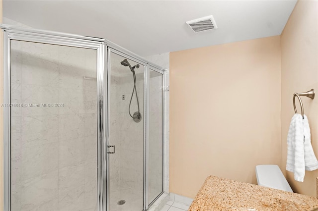 bathroom featuring toilet, tile patterned flooring, an enclosed shower, and vanity