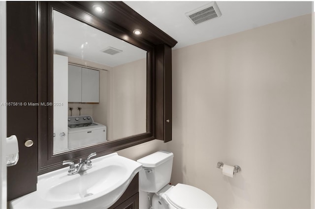 bathroom featuring vanity, toilet, and washer / dryer