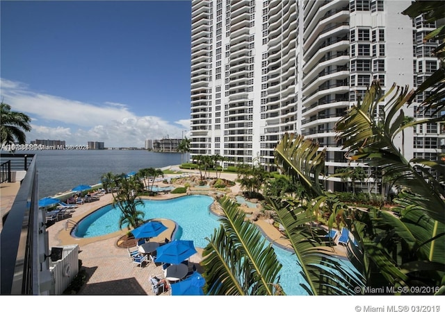 view of pool featuring a water view and a patio area