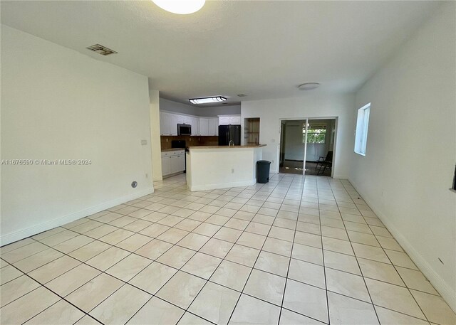 unfurnished living room featuring light tile patterned floors