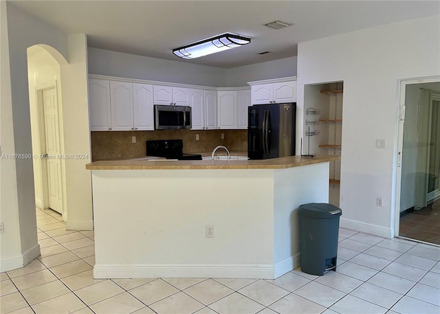 kitchen featuring tasteful backsplash, black range oven, refrigerator with ice dispenser, light tile patterned floors, and white cabinets