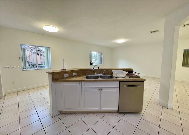 kitchen with white cabinetry, dishwasher, light tile patterned flooring, and sink