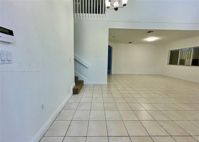 interior space featuring light tile patterned flooring and a chandelier