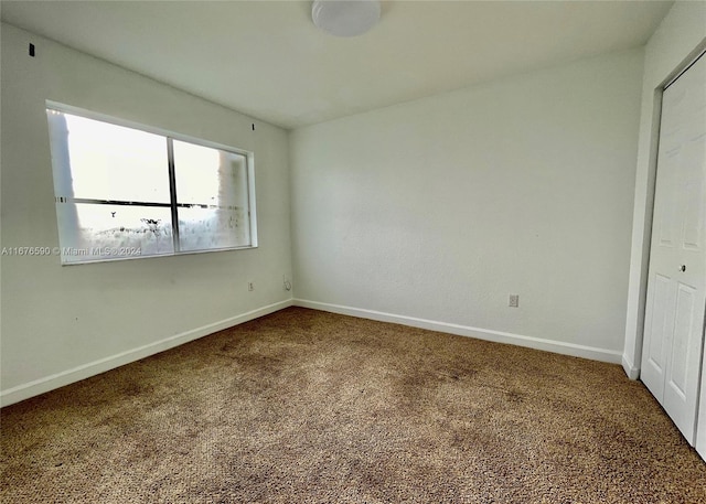 unfurnished bedroom featuring carpet and a closet