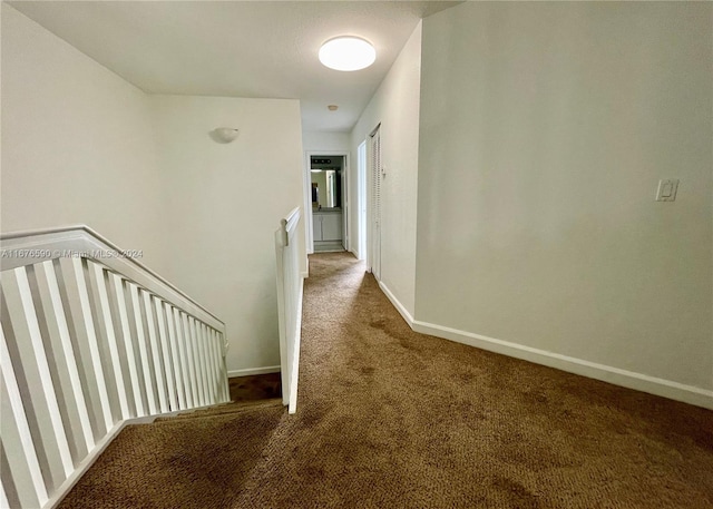 hall featuring dark colored carpet