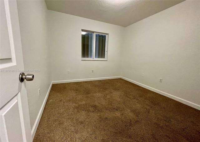 spare room with carpet floors and a textured ceiling