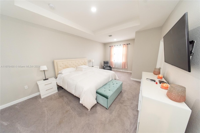 carpeted bedroom with a tray ceiling