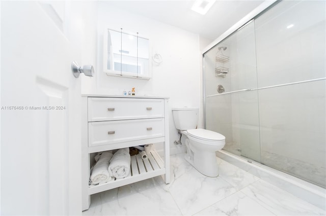 bathroom featuring vanity, toilet, and a shower with shower door