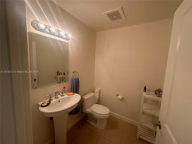 bathroom with sink, toilet, and tile patterned flooring