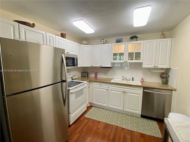 kitchen with stainless steel appliances, light countertops, a sink, and white cabinetry