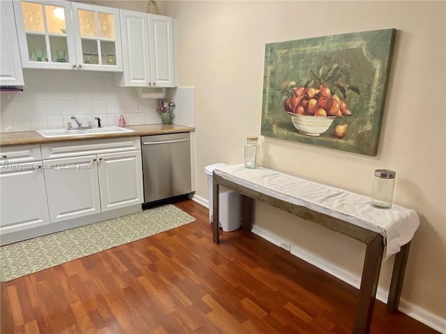 kitchen with sink, dishwasher, white cabinets, dark wood-type flooring, and decorative backsplash