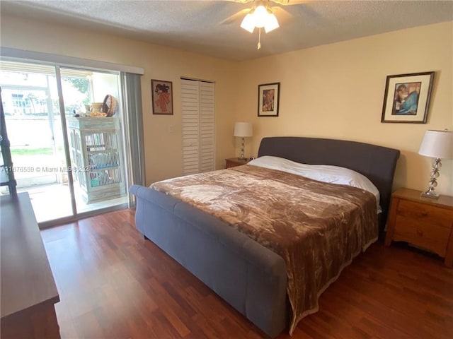 bedroom with ceiling fan, dark hardwood / wood-style flooring, a textured ceiling, access to exterior, and a closet