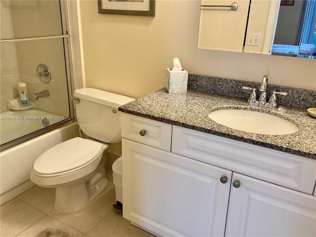 bathroom featuring toilet, shower / bath combination with glass door, vanity, and tile patterned floors