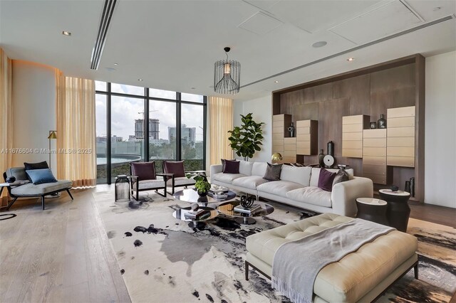 living room featuring a wall of windows and light hardwood / wood-style flooring