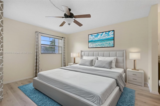 bedroom featuring ceiling fan, a textured ceiling, and light hardwood / wood-style flooring