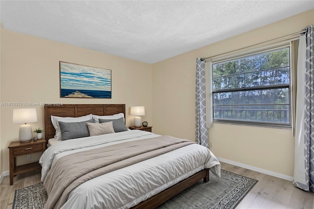 bedroom with light hardwood / wood-style flooring and a textured ceiling