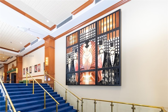 staircase with ornamental molding and high vaulted ceiling