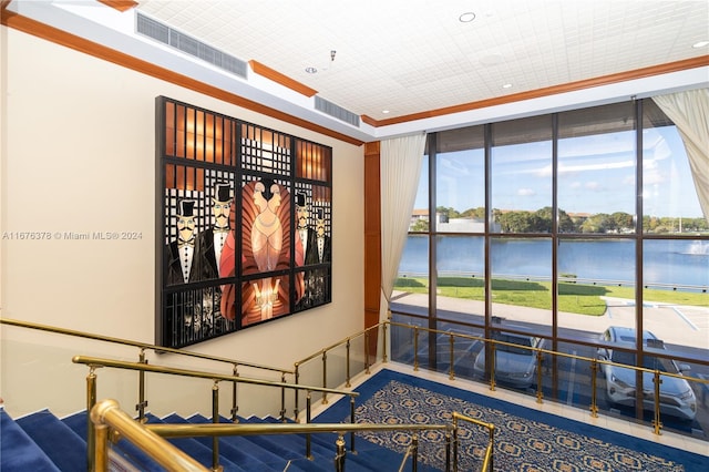 interior space with ornamental molding, a water view, and plenty of natural light