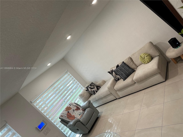 unfurnished living room featuring vaulted ceiling and light tile patterned floors