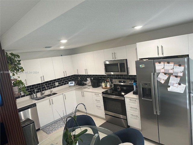 kitchen featuring sink, white cabinetry, stainless steel appliances, and backsplash