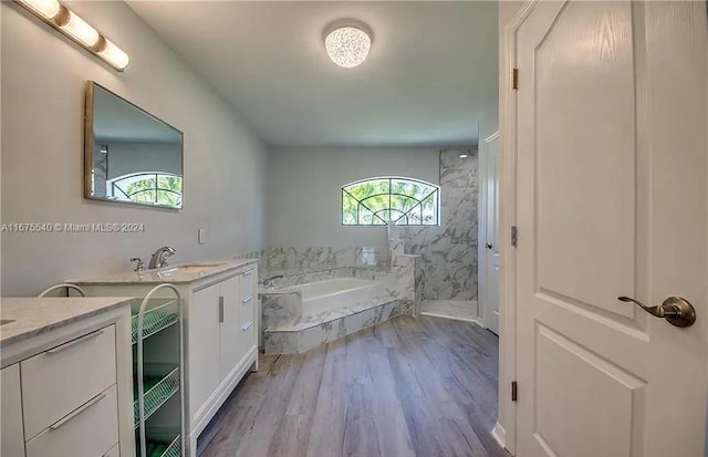 bathroom with hardwood / wood-style floors, vanity, and separate shower and tub