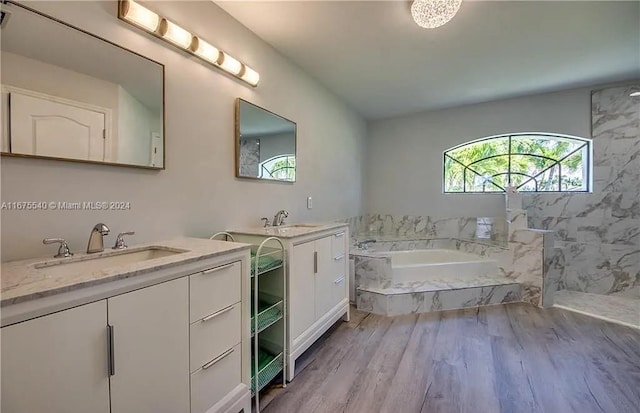 bathroom with hardwood / wood-style floors, vanity, and a bathtub