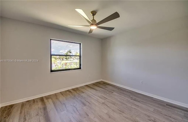 empty room with ceiling fan and light hardwood / wood-style flooring