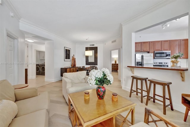 living room featuring ornamental molding and washing machine and clothes dryer