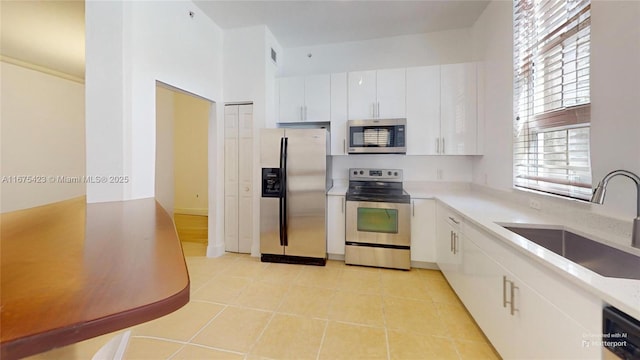 kitchen featuring light countertops, white cabinets, a sink, and stainless steel appliances