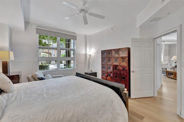 bedroom featuring visible vents, ceiling fan, and light wood-style flooring
