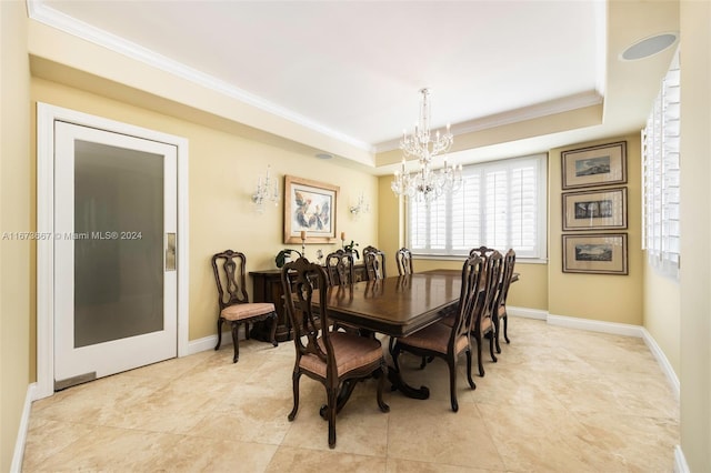 dining area featuring a notable chandelier, a tray ceiling, and crown molding