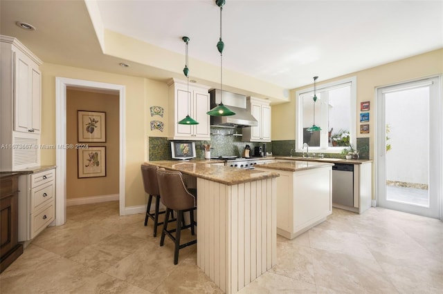 kitchen featuring appliances with stainless steel finishes, a center island, plenty of natural light, and pendant lighting