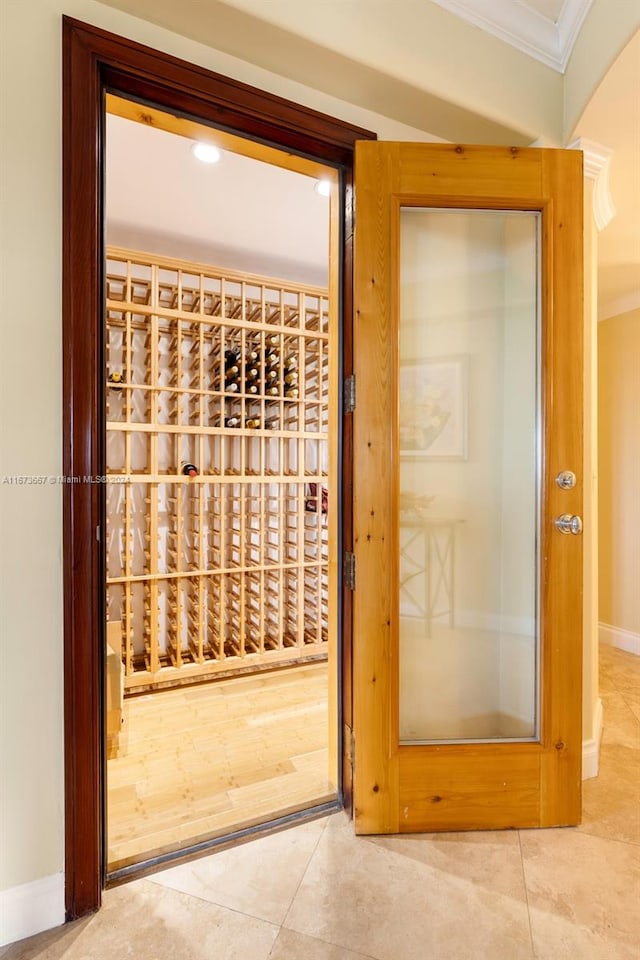 wine room featuring ornamental molding and tile patterned flooring